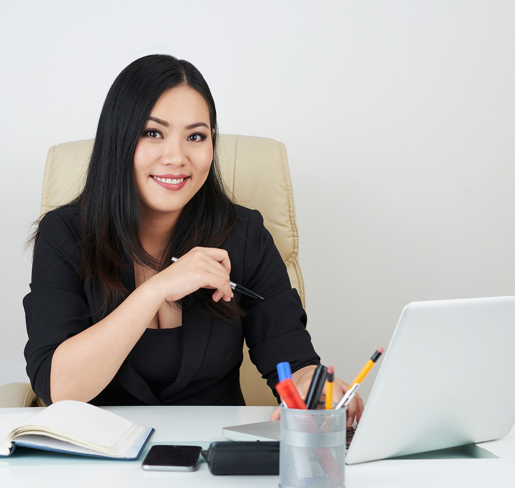 Female entrepreneur working confidently at her office desk